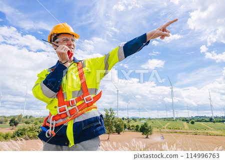 engineer male control operate field working outdoor service maintenance wind power generator. worker hand pointing location to order gesture 114996763