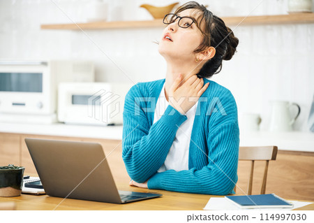 A woman suffering from stiff shoulders due to teleworking A woman suffering from stiff shoulders due to teleworking 114997030