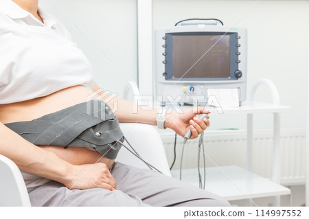 Woman Undergoing CTG to Monitor Fetal Heartbeat Woman Undergoing CTG to Monitor Fetal Heartbeat 114997552