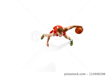 Aerial view of young athletic man, dressed red gear basketball player dribbling in motion against white studio background. 114998396