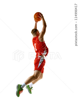Basketball player, dressed in red uniform, performing perfect slam dunk against white studio background. Basketball player, dressed in red uniform, performing perfect slam dunk against white studio background. 114998417