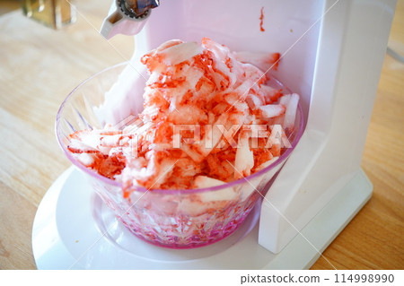 Frozen strawberry shaved ice made by shaving delicious frozen strawberries using a shaved ice machine. 114998990