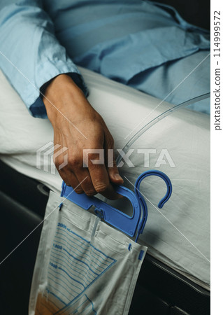 man in bed wearing a urinary catheterization man in bed wearing a urinary catheterization 114999572