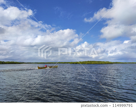 Man on a Motorized Outrigger Boat 114999791