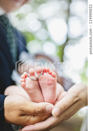 Parents touching their newborn son's feet 114999852