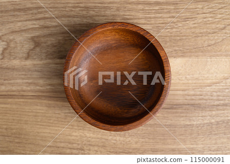 A wooden bowl on wooden background, Table top view A wooden bowl on wooden background, Table top view 115000091