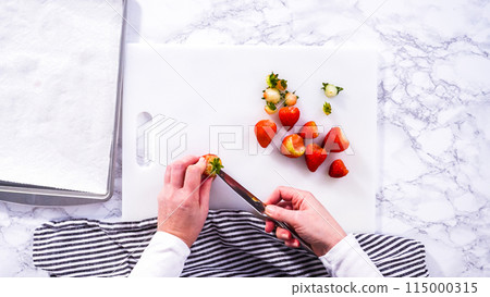 Flat lay. Succulent red strawberries, some showing early spoilage, are arrayed on a white cutting board, held securely in place, with a paper towel lined glass bowl nearby suggesting an attempt at Flat lay. Succulent red strawberries, some showing early spoilage, are arrayed on a white cutting board, held securely in place, with a paper towel lined glass bowl nearby suggesting an attempt at 115000315