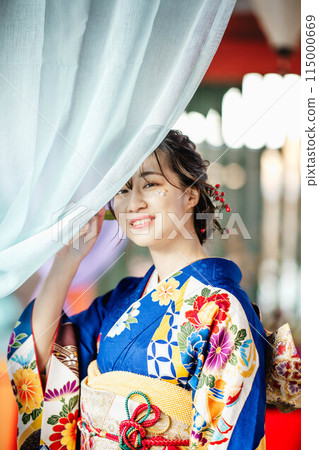 一位穿著日本服裝的年輕女子透過彩色布料之間的縫隙望去 115000669