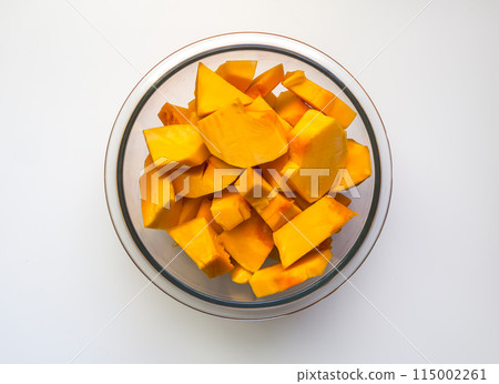 Chopped fresh raw pumpkin prepared for cooking. Healthy vegetarian food ingredient. Chopped fresh raw pumpkin prepared for cooking. Healthy vegetarian food ingredient. 115002261