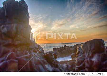 Ocean waves to rocks in sunset 115002990