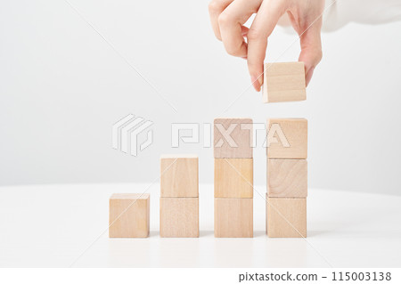 Woman's hands stacking wooden blocks Woman's hands stacking wooden blocks 115003138
