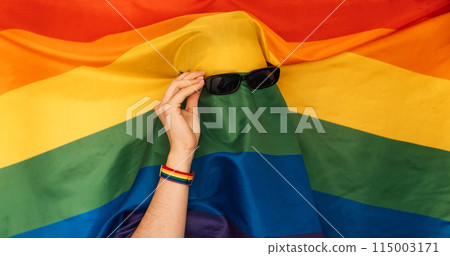 LGBT flag on a man wearing sunglasses LGBT flag on a man wearing sunglasses 115003171