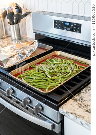 Watch as fresh green beans are beautifully roasted to perfection on a baking sheet with a silicone mat, adding a burst of flavor to your meal. 115003530