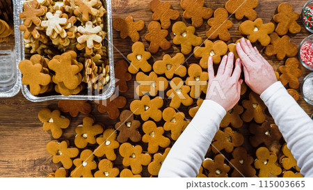 Flat lay. Crafting gingerbread cookie sandwiches with eggnog buttercream, presented on a rustic wooden table for Christmas gifting. Flat lay. Crafting gingerbread cookie sandwiches with eggnog buttercream, presented on a rustic wooden table for Christmas gifting. 115003665