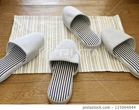 Two pairs of slippers scattered on a mat Two pairs of slippers scattered on a mat 115004044