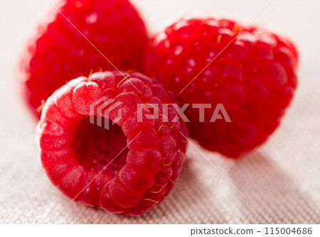 Three raspberry berries on white background 115004686