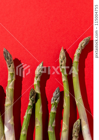 Green asparagus on red background. Vegetable food top view. 115004755
