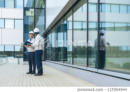 A group of multinational engineers having a conversation in front of a building 115004944