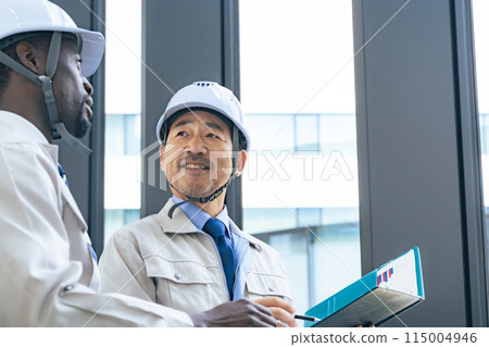 Group of multinational engineers having a conversation in a building Group of multinational engineers having a conversation in a building 115004946