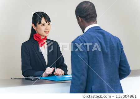 一位女士在櫃檯為外國遊客服務 115004961