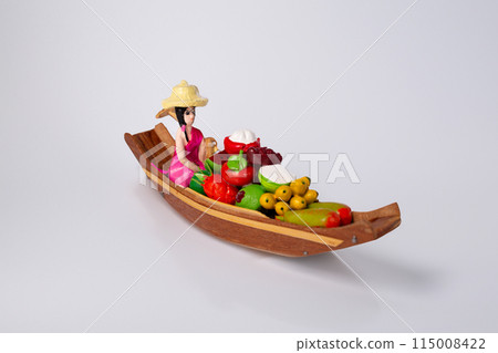 Boat with fruit and a woman on white background. A traditional Thailand souvenir Boat with fruit and a woman on white background. A traditional Thailand souvenir 115008422
