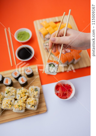 Sushi delivery. Set of rolls in a disposable box on a black background. Top view 115009167
