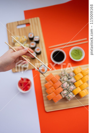 Sushi delivery. Set of rolls in a disposable box on a black background. Top view 115009168