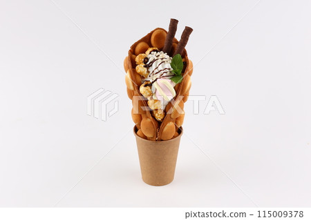 Trendy Hong Kong bubble waffles with ice cream, cream and berries on white wooden background. Copy space Trendy Hong Kong bubble waffles with ice cream, cream and berries on white wooden background. Copy space 115009378