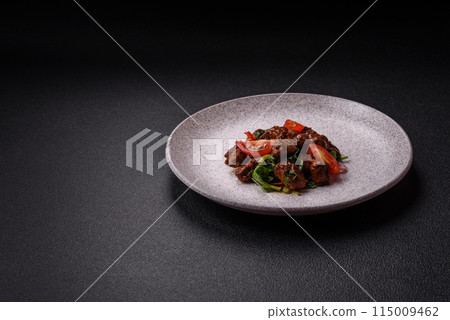 Delicious warm salad with pieces of meat, spinach, tomatoes, salt, spices and herbs 115009462