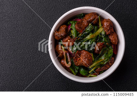 Delicious warm salad with pieces of meat, spinach, tomatoes, salt, spices and herbs Delicious warm salad with pieces of meat, spinach, tomatoes, salt, spices and herbs 115009485