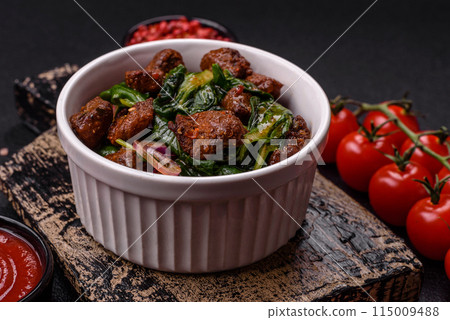 Delicious warm salad with pieces of meat, spinach, tomatoes, salt, spices and herbs 115009488