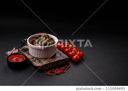 Delicious warm salad with pieces of meat, spinach, tomatoes, salt, spices and herbs 115009493