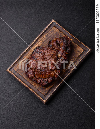 Delicious juicy beef ribeye steak grilled with salt, spices and herbs Delicious juicy beef ribeye steak grilled with salt, spices and herbs 115009589