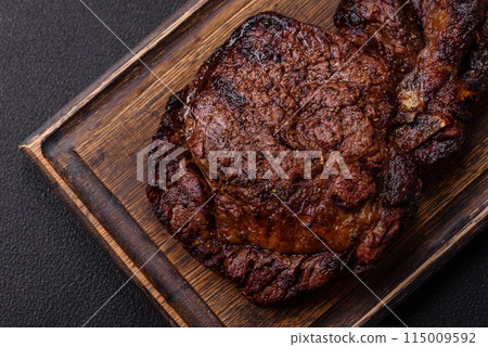 Delicious juicy beef ribeye steak grilled with salt, spices and herbs Delicious juicy beef ribeye steak grilled with salt, spices and herbs 115009592