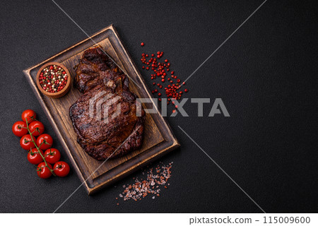 Delicious juicy beef ribeye steak grilled with salt, spices and herbs 115009600