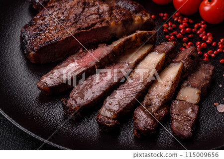 Delicious juicy beef ribeye steak grilled with salt, spices and herbs Delicious juicy beef ribeye steak grilled with salt, spices and herbs 115009656