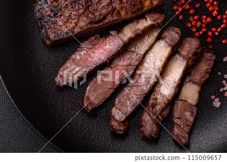 Delicious juicy beef ribeye steak grilled with salt, spices and herbs Delicious juicy beef ribeye steak grilled with salt, spices and herbs 115009657