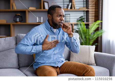 A man at home shows distress, coughing, chest pain. Urgent medical aid may be necessary. A man at home shows distress, coughing, chest pain. Urgent medical aid may be necessary. 115010256