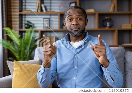 A professional African American man demonstrates essential leadership qualities in a virtual meeting from a modern home office. He showcases skills for remote work and business interactions A professional African American man demonstrates essential leadership qualities in a virtual meeting from a modern home office. He showcases skills for remote work and business interactions 115010275