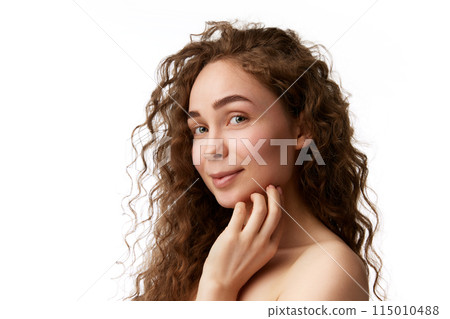 Portrait of beautiful young woman with curly hair, spotless wellness skin looking at camera isolated on white background 115010488