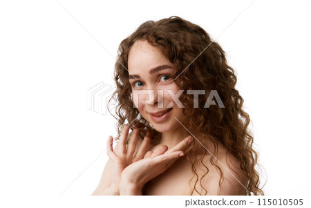 Feeling confident with no makeup look. Beautiful woman with curly hair demonstrating well-kept skin isolated on white background 115010505
