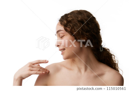 Soft touch. Smiling beautiful young woman with bare shoulders taking care after skin isolated on white background. Organic products Soft touch. Smiling beautiful young woman with bare shoulders taking care after skin isolated on white background. Organic products 115010561