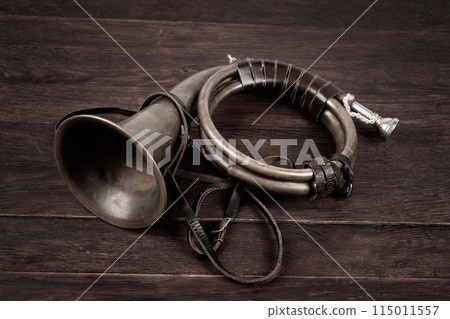 Hunting horn on rustic wood plank. 115011557
