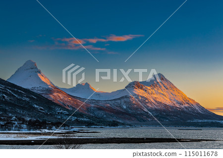The magical light of the ending polar day on the snowy hills of Lofoten, Norway 115011678