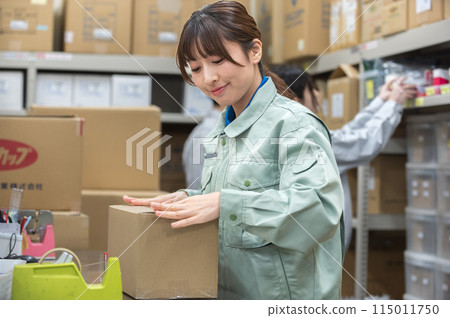A young woman in work clothes packing 115011750