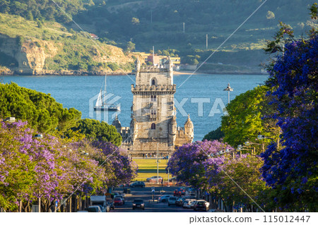 Belem Tower, Jacaranda Blooming Purple Blue Trees and Sailboat on Sunny Evening. Golden Hour. Lisbon Belem Tower, Jacaranda Blooming Purple Blue Trees and Sailboat on Sunny Evening. Golden Hour. Lisbon 115012447