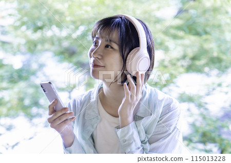 在智能手機上聽音樂的年輕女子帶耳機 115013228