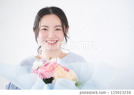 年輕女子收到一束花，看著相機 115013238