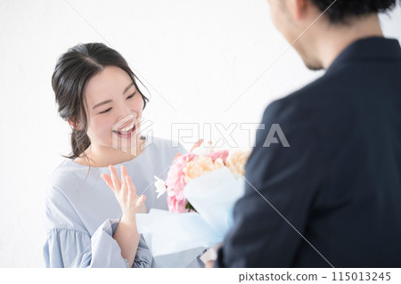 A young woman receiving a bouquet of flowers and a man giving it (no faces) A young woman receiving a bouquet of flowers and a man giving it (no faces) 115013245