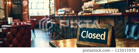 Rustic bar interior with 'Closed' sign on a wooden table, cozy and inviting ambiance. 115015970